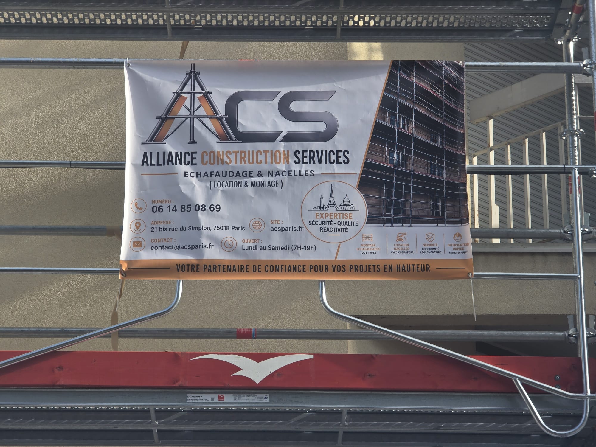 Panneau ACS Alliance Construction Services sur l'échafaudage du chantier